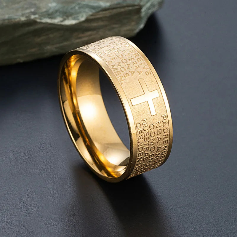 Gold ring with cross design on a dark surface
