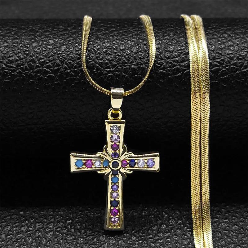 Gold cross pendant necklace with colorful stones on a black textured background