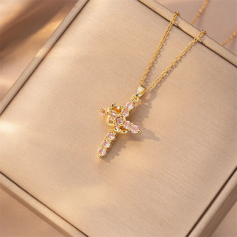 Gold necklace with a pink gemstone pendant on a beige jewelry box