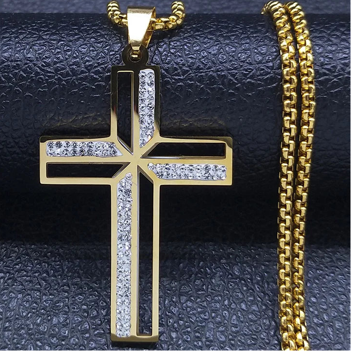 Gold cross pendant with chain on a textured black surface