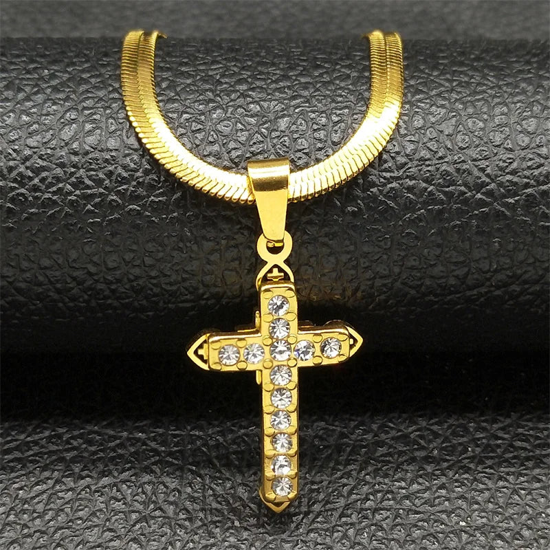 Gold cross pendant with clear stones on a black textured background