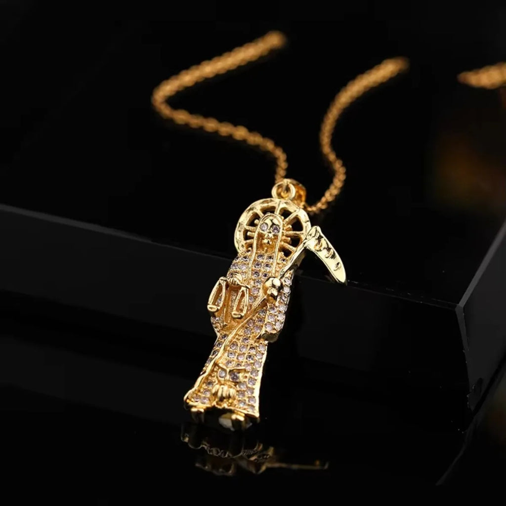 Gold necklace with a pendant on a black reflective surface