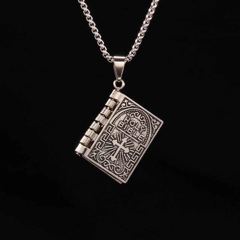 Silver book-shaped pendant on a chain against a black background