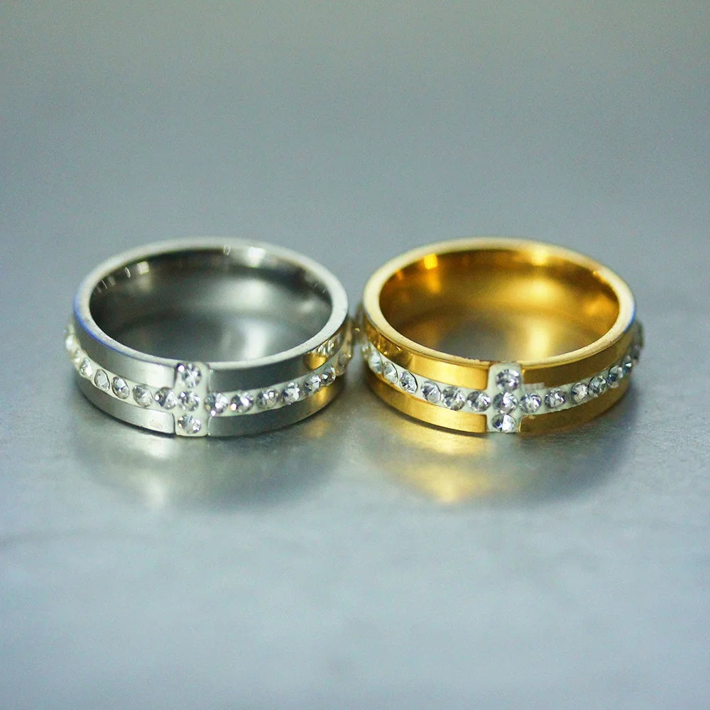 Two rings, one silver and one gold, with embedded stones on a gray background