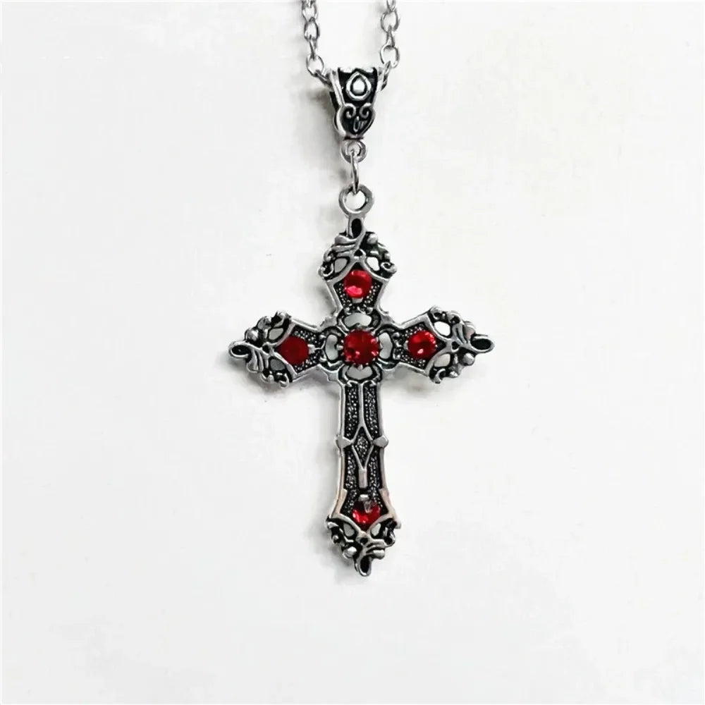 Silver cross necklace with red stones on a white background