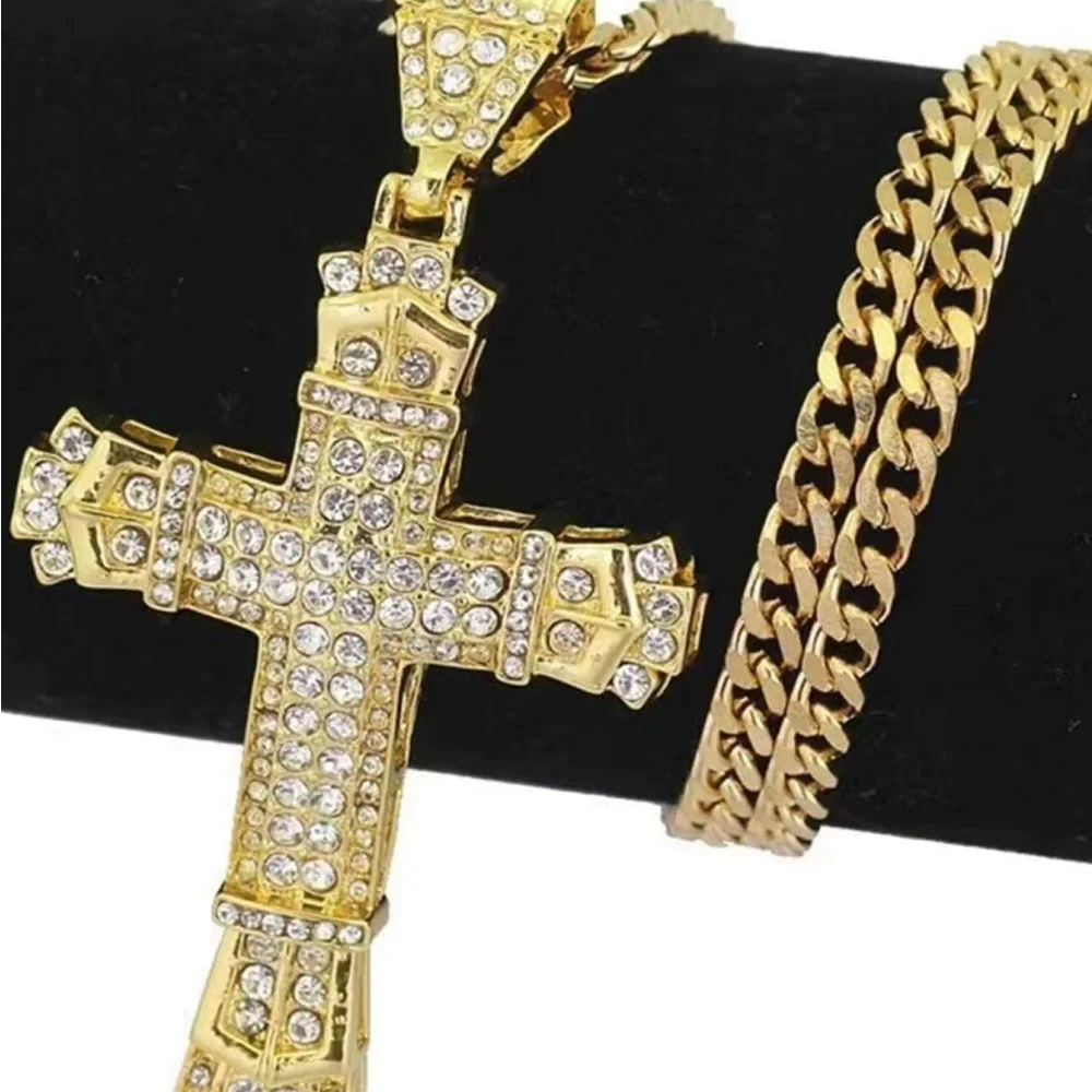 Gold cross pendant and chain on a black background