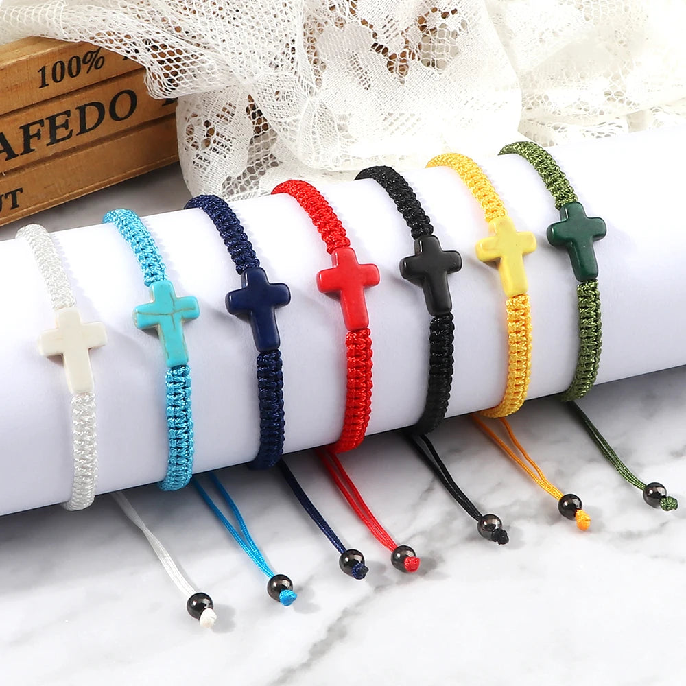 Set of colorful bracelets with cross designs on a white surface.