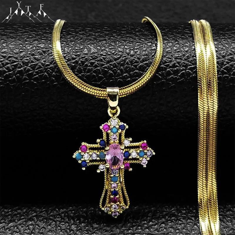 Gold cross pendant necklace with colorful gemstones on a black textured background