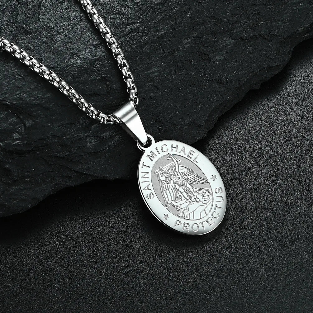 Silver Saint Michael pendant necklace on a dark stone surface
