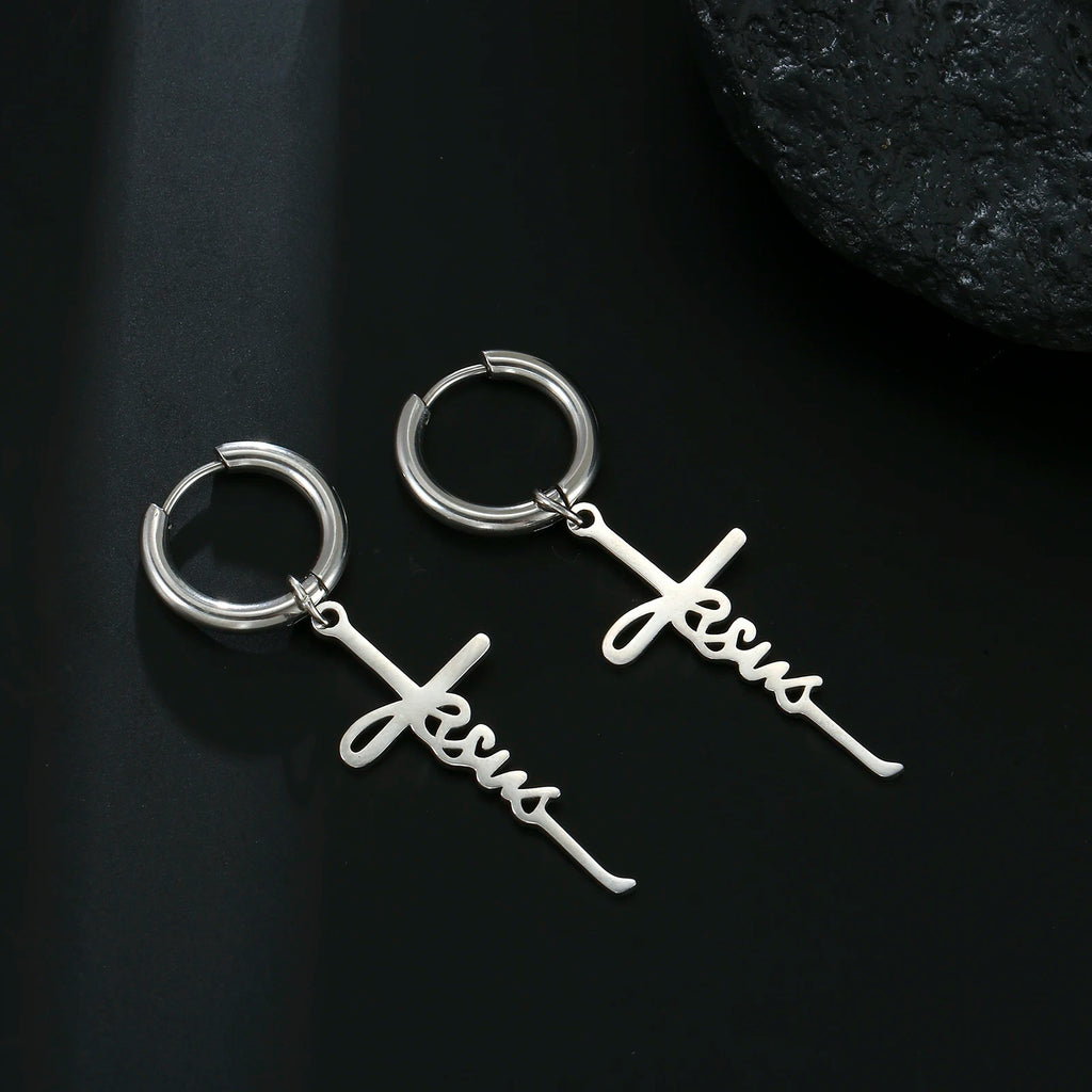 Silver hoop earrings with 'Jesus' script on a white fabric background