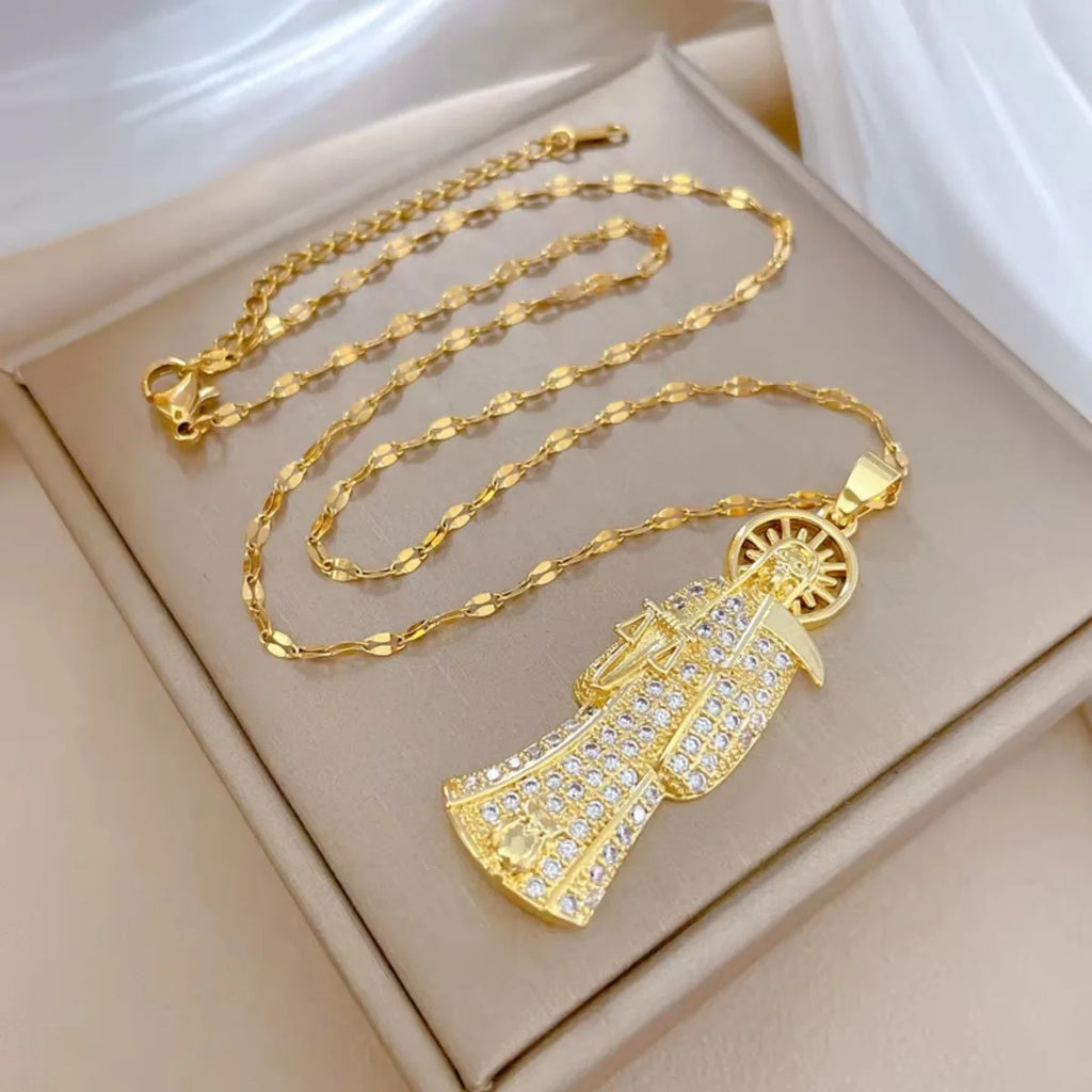 Gold necklace with a detailed pendant on a beige box