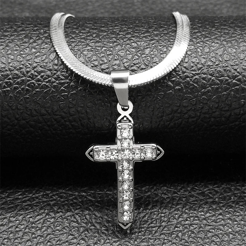Silver cross pendant necklace on a textured black surface