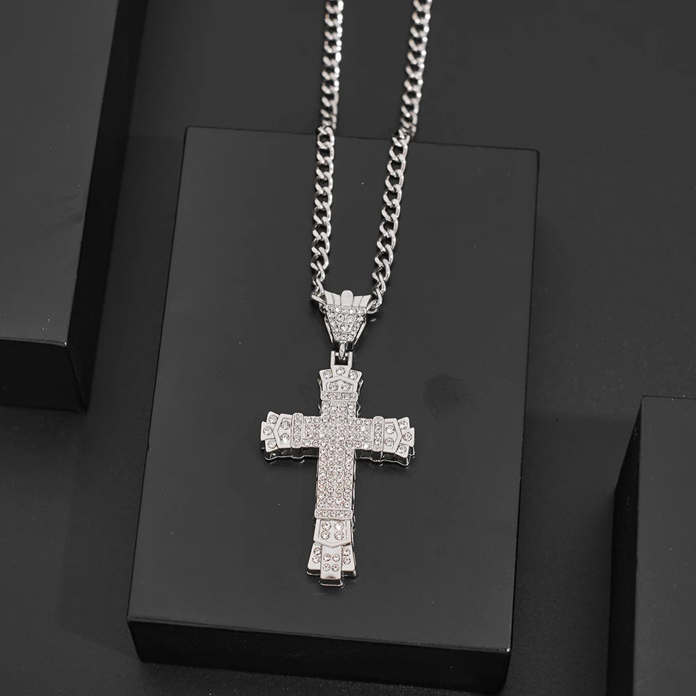 Silver cross pendant necklace on a black stand