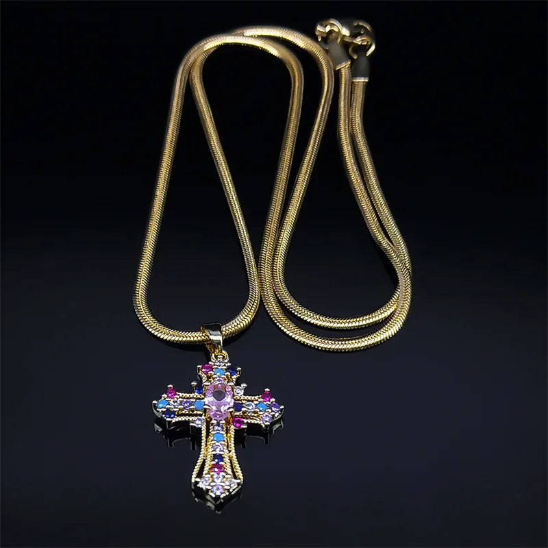 Gold necklace with a cross pendant featuring colorful gemstones on a black background