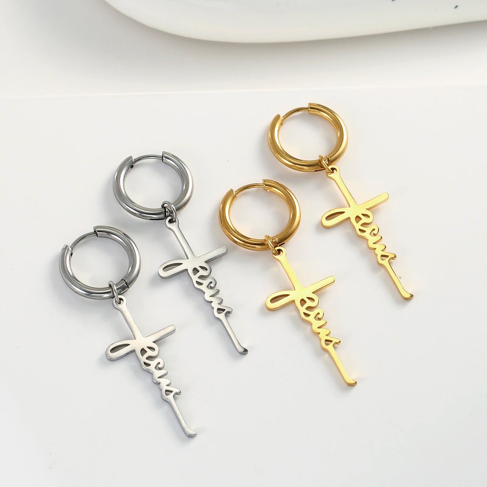 Three keychains with 'Jesus' and cross designs in silver, gold, and rose gold on a white background.