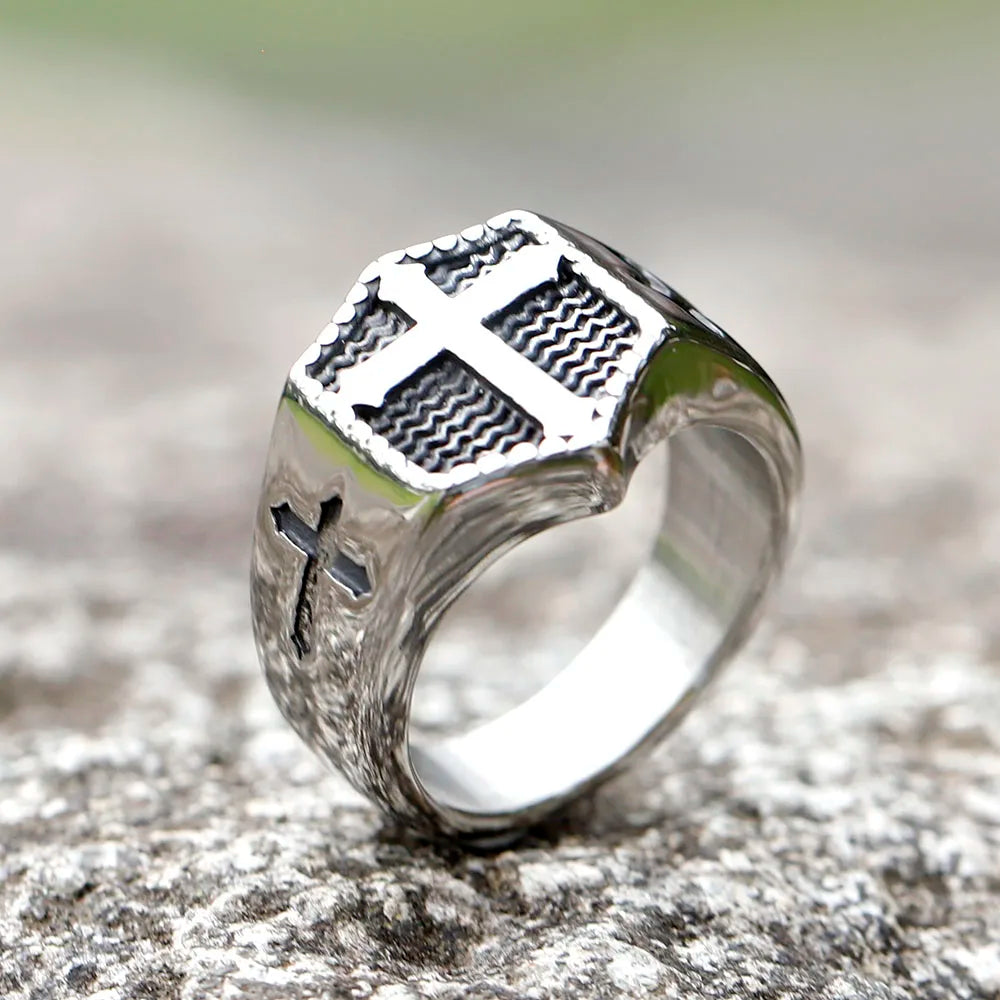 Silver ring with cross design on a textured surface