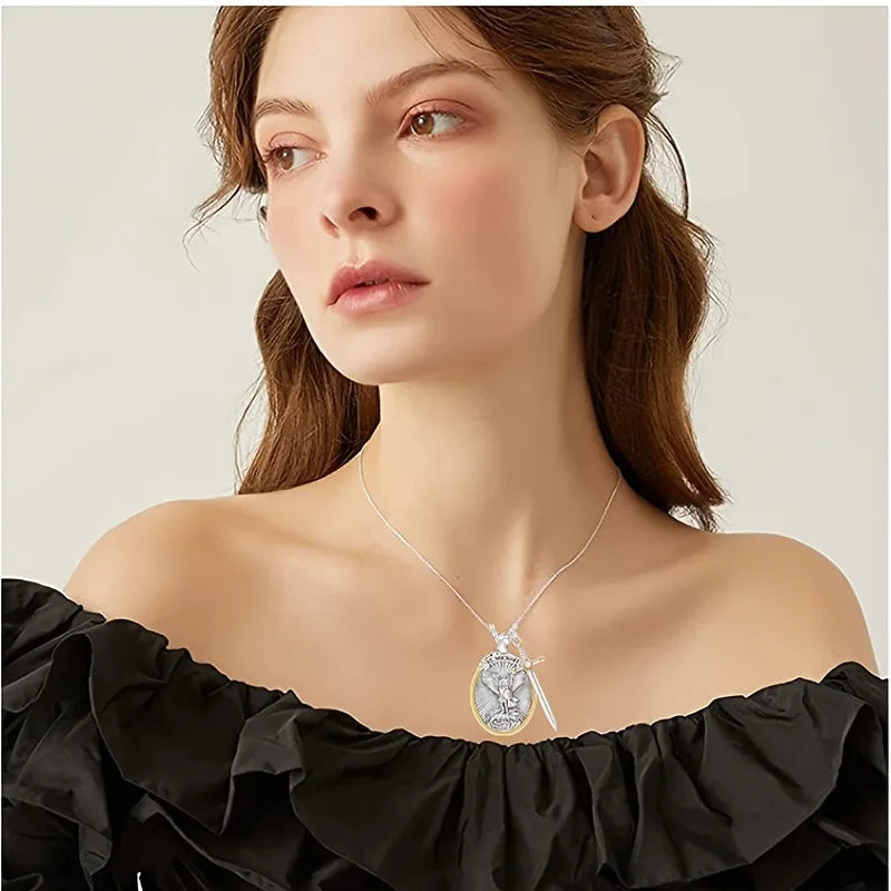 Woman wearing a silver necklace with a pendant against a neutral background