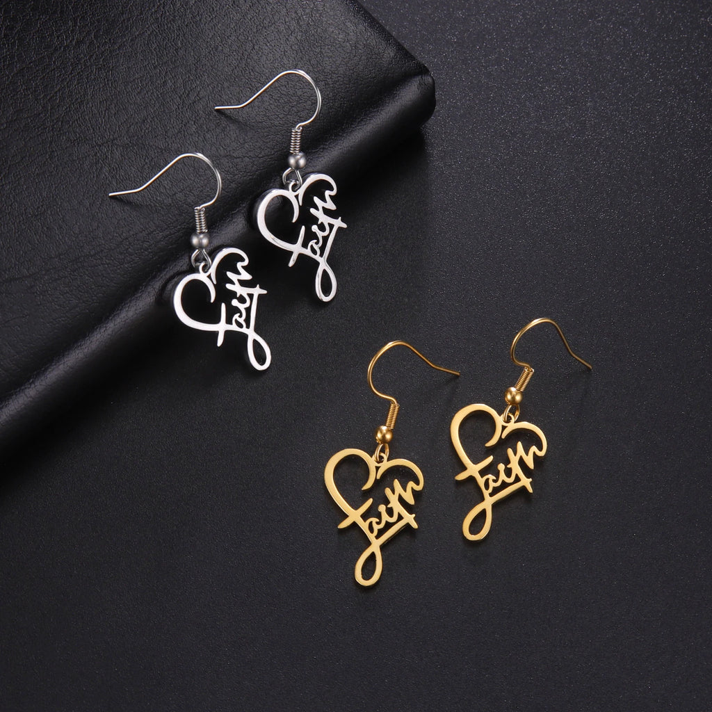 Silver and gold 'Faith' heart-shaped earrings on a black background