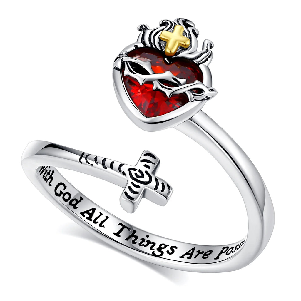 Silver ring with red stone and cross design on a white background