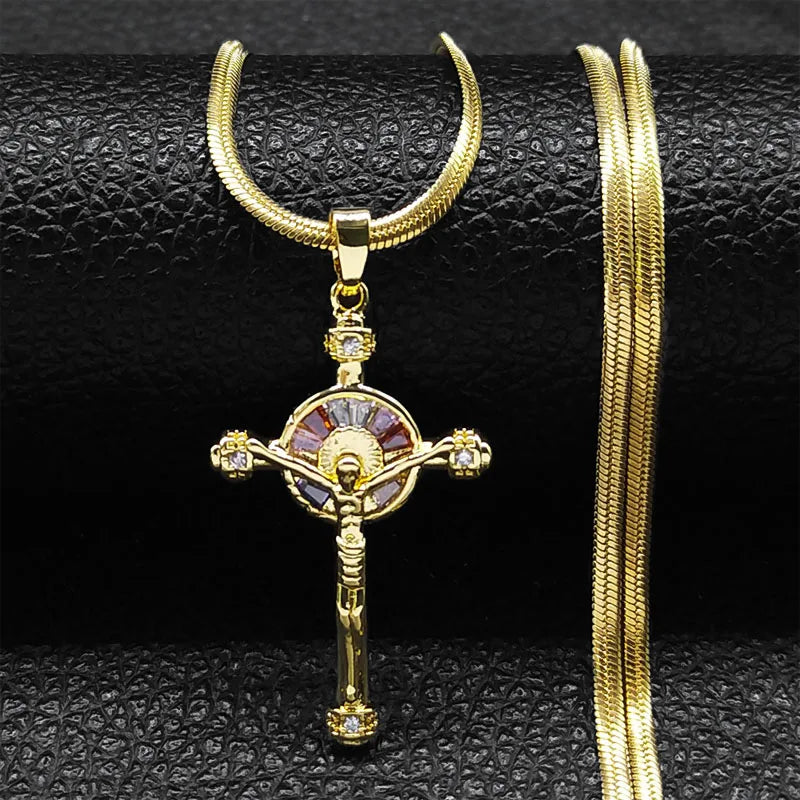Gold crucifix pendant necklace on a textured black surface