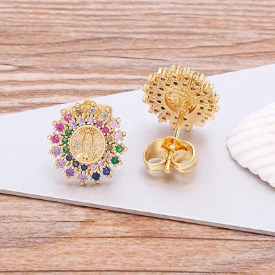 Gold earrings with gemstones on a wooden surface