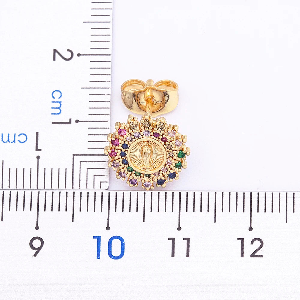 Gold pendant with colorful stones measured against a ruler