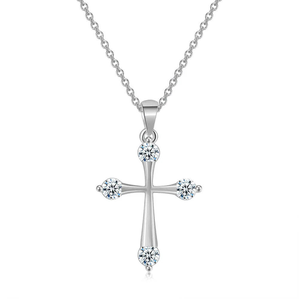 Silver cross pendant necklace with clear gemstones on a white background
