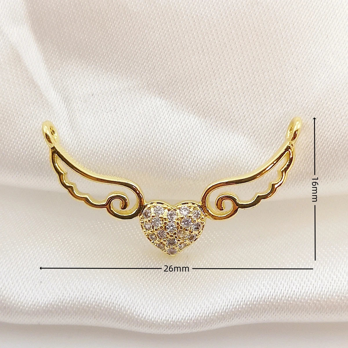 Gold heart-shaped earring with wings on a white background
